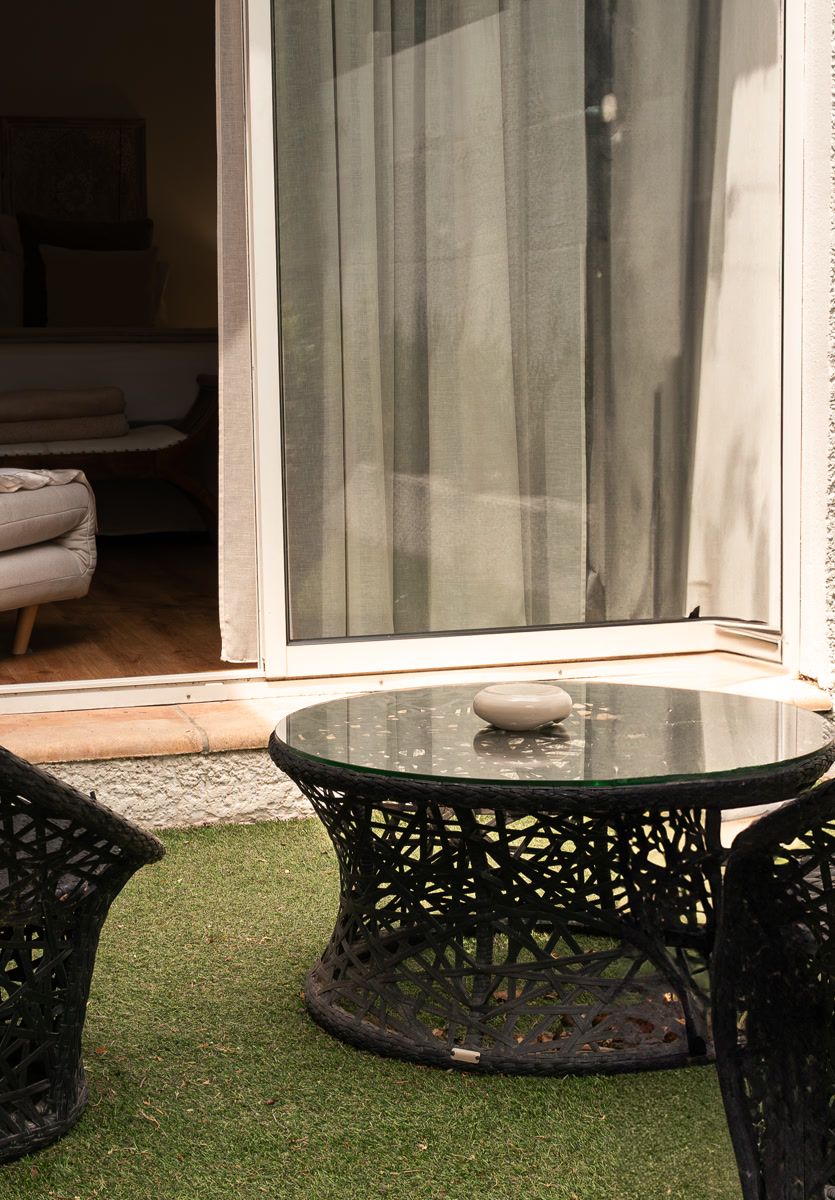 Le jardinet privé de La Bégude, ses fauteuils tressés et sa table basse