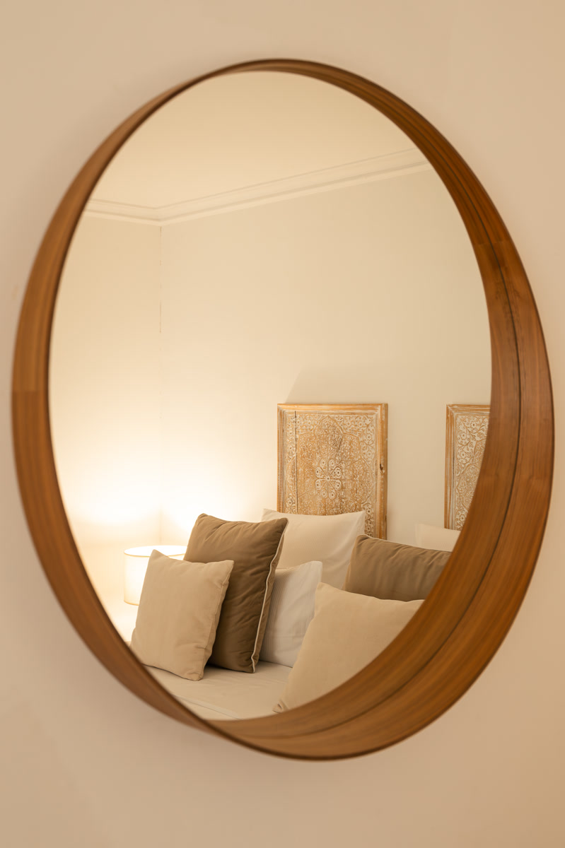 Le lit de La Bégude aperçu dans le grand miroir rond de bois