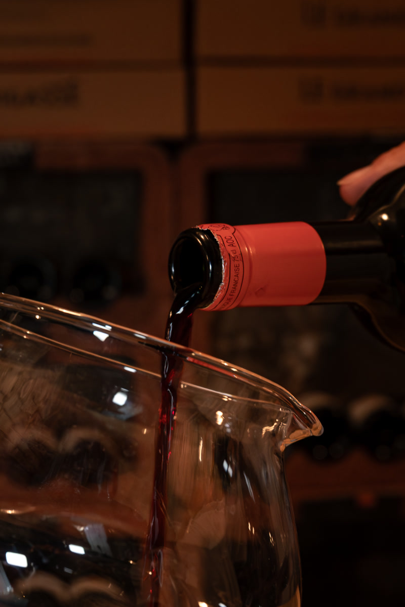 Le vin versé en carafe, à la lumière de la cave