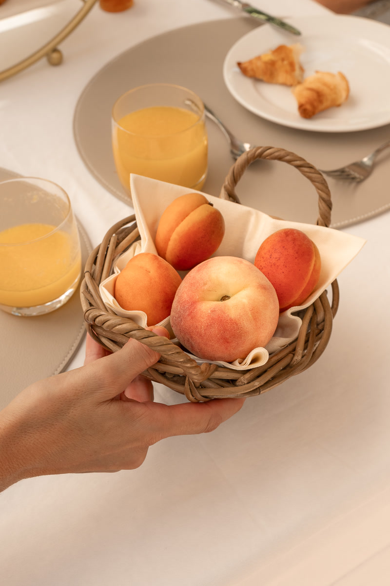 Le panier d'abricots et de pêches tendu au-dessus de la table