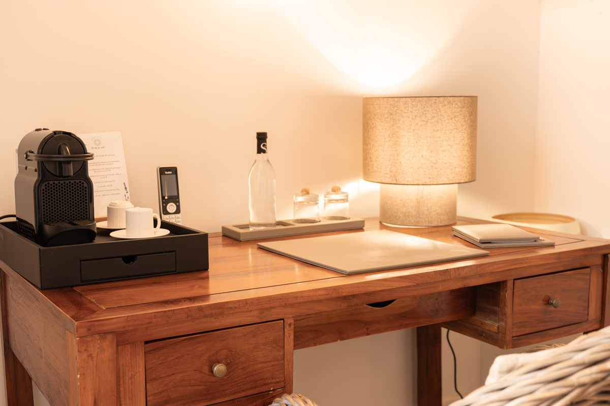 Le bureau en bois, la machine à café et la lampe allumée