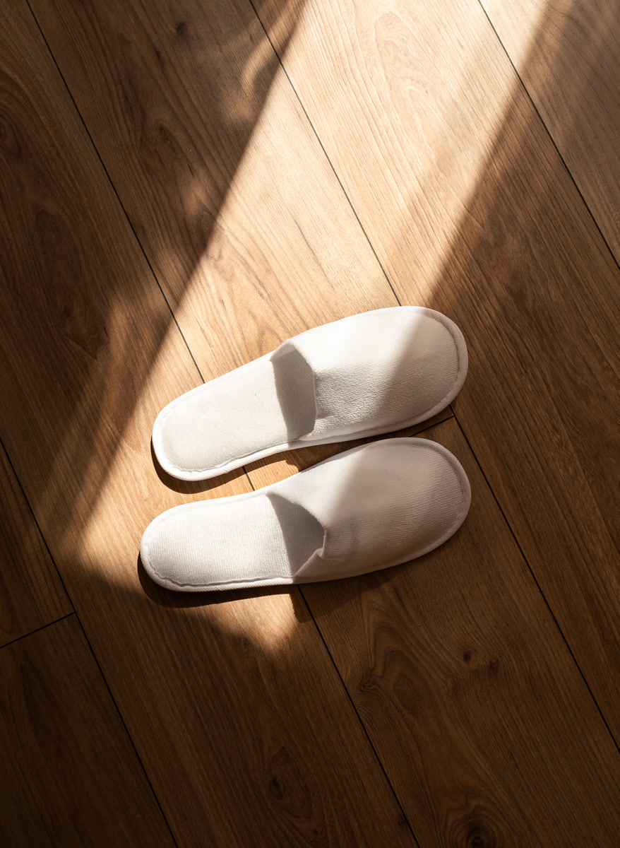 Les chaussons de la chambre dans la lumière rasante du matin