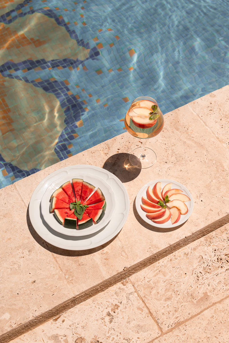 Un verre et des fruits frais servis au bord de la piscine