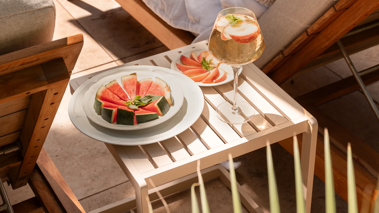 Fruits frais et cocktail servis sur une table basse entre les transats