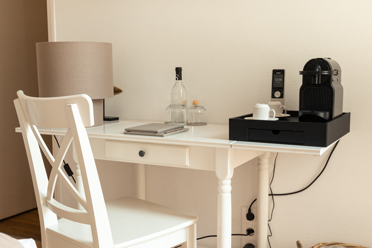 Le bureau blanc, la machine à café et la carafe d'eau offerte