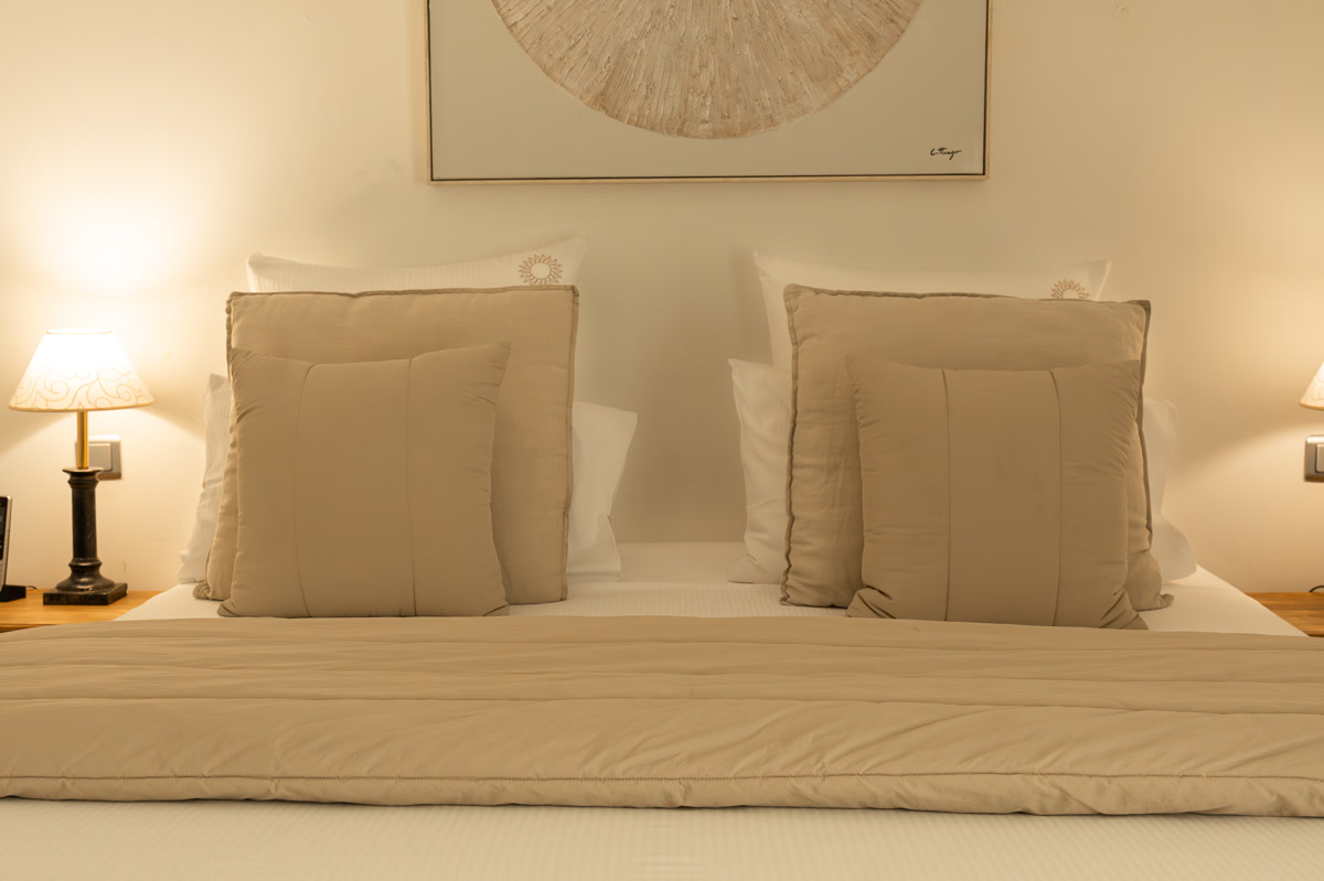 La chambre La Simone, le lit face au tableau rond, symétrie des coussins