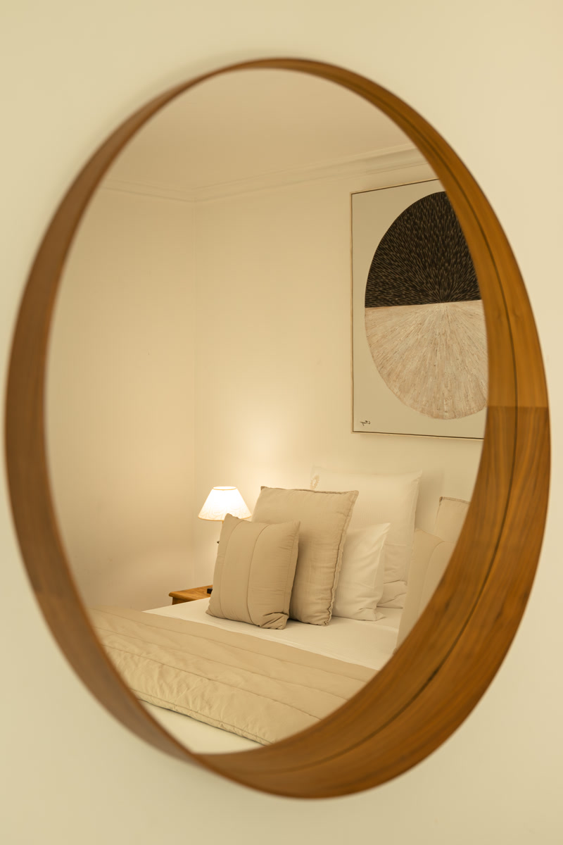 Le lit de La Simone reflété dans le miroir rond en bois