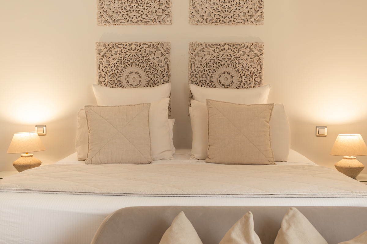 Le lit de La Terre Blanche face aux quatre panneaux de bois sculpté