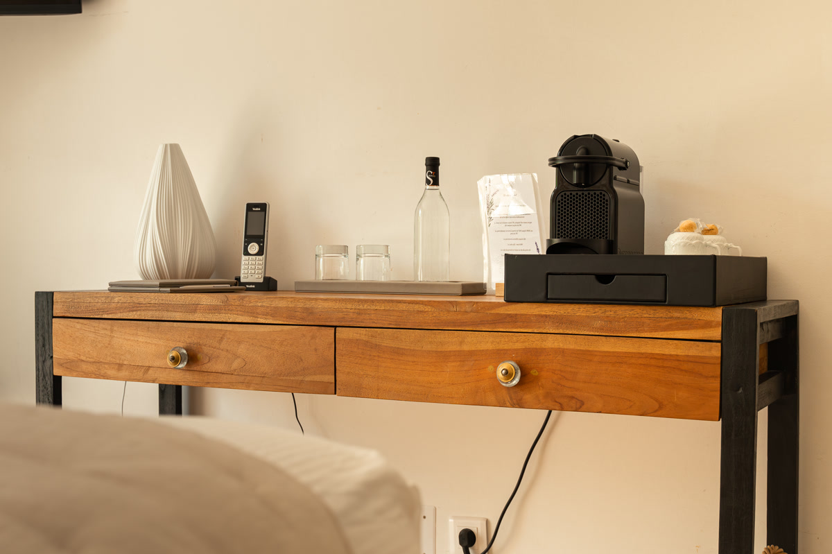 La console de bois, la machine à café et la carafe d'eau offerte