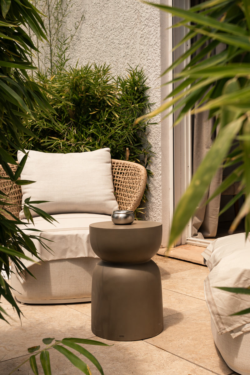 Le fauteuil en rotin du jardinet, parmi la verdure